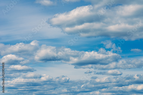 White clouds in the blue sky. White light cloudy heaven,good weather. Summer sky. Heaven and infinity. Curly clouds on a sunny day. Beautiful bright blue background.