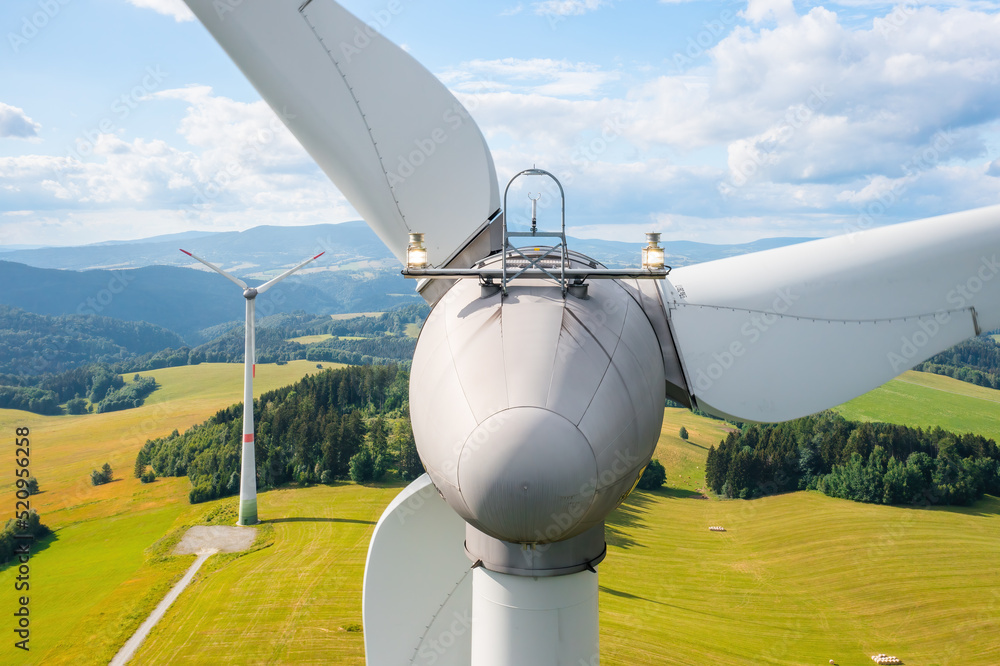 Close up a propeller of the windmill in the yellow field with mountains in the background - obrazy, fototapety, plakaty 