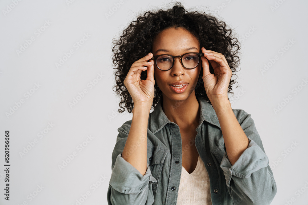 Black curly woman wearing eyeglasses posing and looking at camera Black curly woman wearing eyeglasses posing and looking at camera