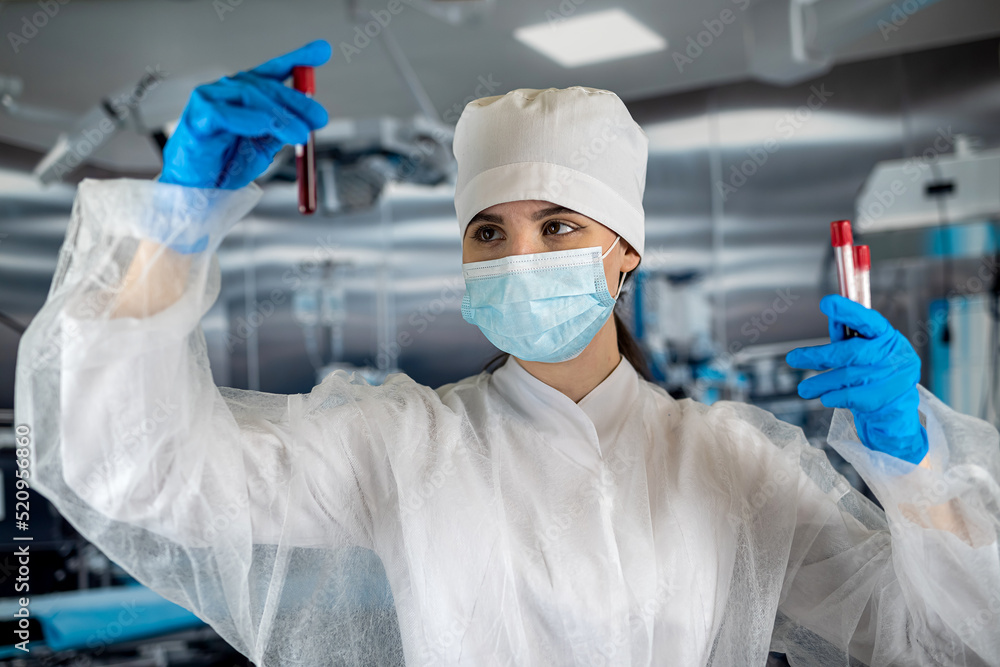 female nurse holds a blood test in a test tube of a person. female nurse holds a blood test in a test tube of a person.