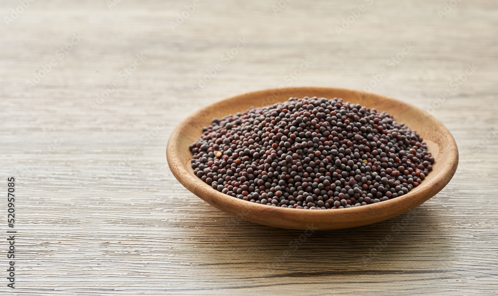 black mustard seed in wood plate on wooden table background. a pile of black mustard seed in wood plate on wooden table background. black mustard seed in wood plate on wooden table background. a pile of black mustard seed in wood plate on wooden table background.