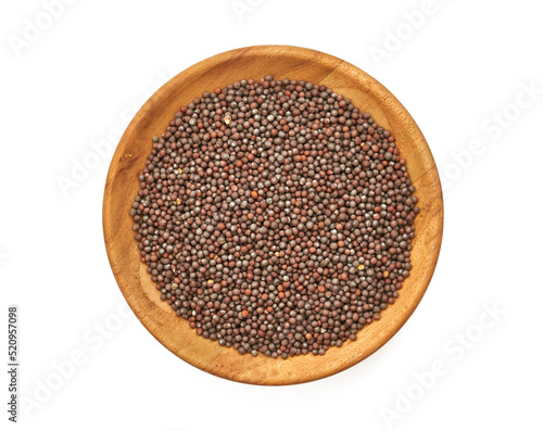 top view black mustard seed in wood plate isolated on background. a pile of black mustard seed in wood plate isolated on background. heap of black mustard seed in wood plate isolated on backgroun