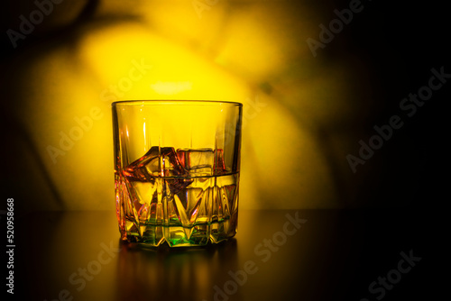 glass with ice on a colorful background © alastis