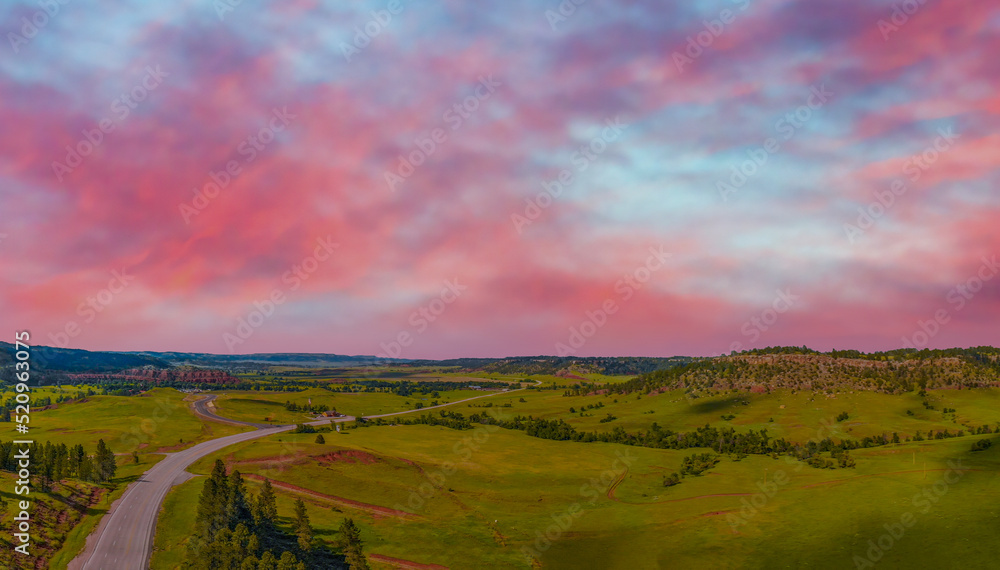 Panoramic aerial view of Devils Tower surrounding countryside at summer sunset, Wyoming