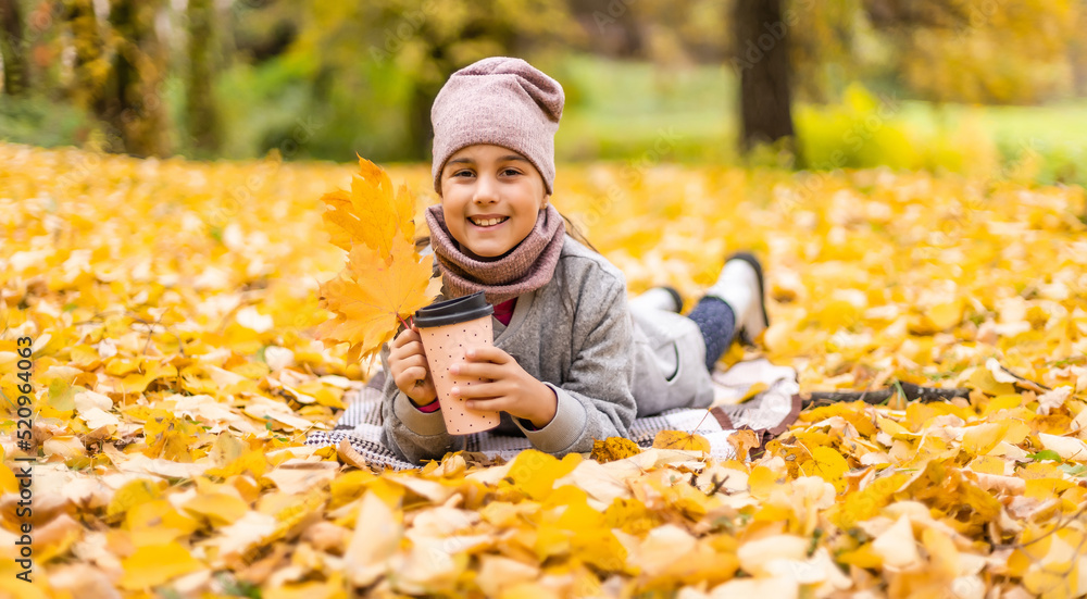 Little funny girl lies on yellow leaves in the forest. Child on a walk in the autumn park. Preschool girl Little funny girl lies on yellow leaves in the forest. Child on a walk in the autumn park. Preschool girl
