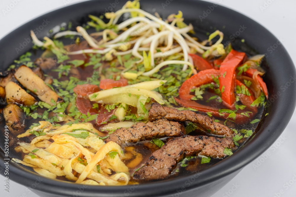 Korean dish soup with noodles, meat and soybean sprouts in a black plate, macro photo
Korean dish soup with noodles, meat and soybean sprouts in a black plate, macro photo
