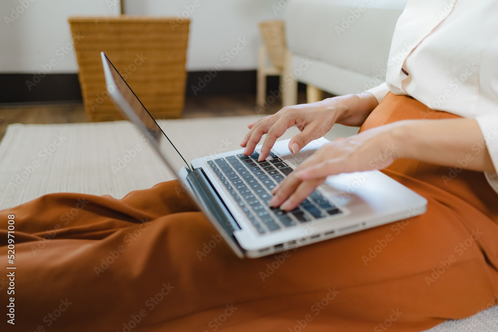 Working by using a laptop computer on wooden table. Hands typing on a keyboard.technology e-commerce concept Working by using a laptop computer on wooden table. Hands typing on a keyboard.technology e-commerce concept