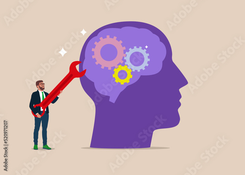 Businessman with wrench to adjust gear cogwheels on human head metaphor of mindset. Change psychology or brain training to learn new skill to success, mentor.