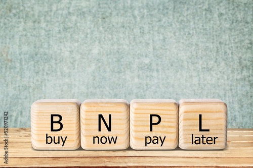 BNPL text in wooden blocks. Buy now pay later concept on the background photo