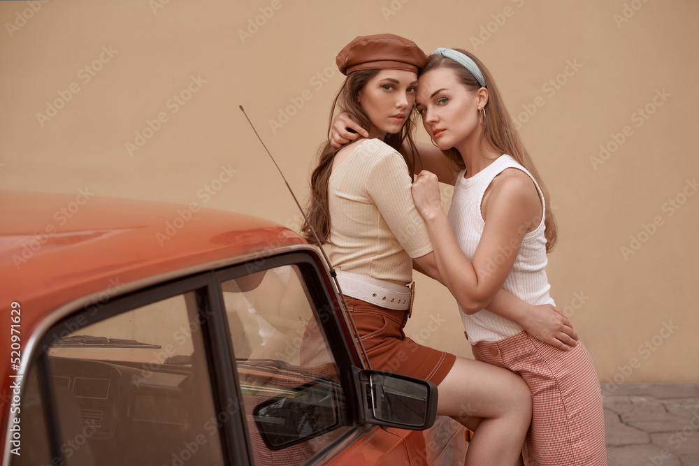 Young beautiful models dressed in retro vintage style enjoying the old european city summertime lifestyle. Old fashioned clothes.