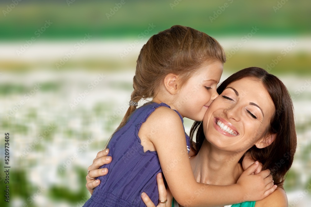 Tender mother and daughter happy together, hugging in nature in a field on a summer day Tender mother and daughter happy together, hugging in nature in a field on a summer day