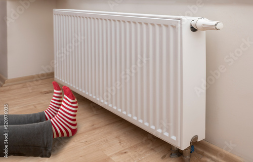 Wallpaper Mural Woman  wearing colorful pair of woolly socks warming cold feet in front of heating radiator in winter time. close up Torontodigital.ca