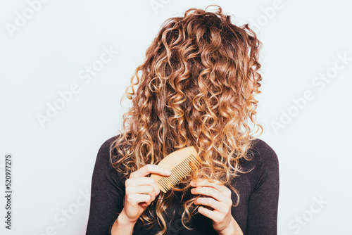 Woman combing her naturally curly hair photo