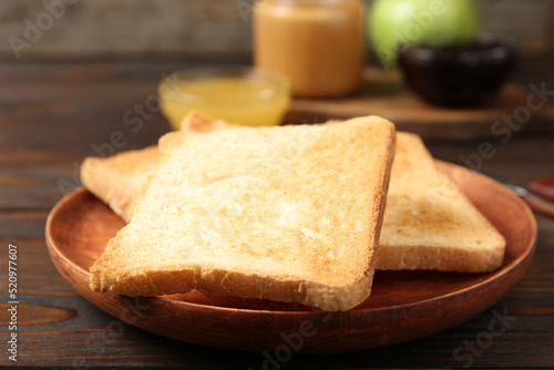 Crispy toasts on wooden table, closeup. Delicious breakfast