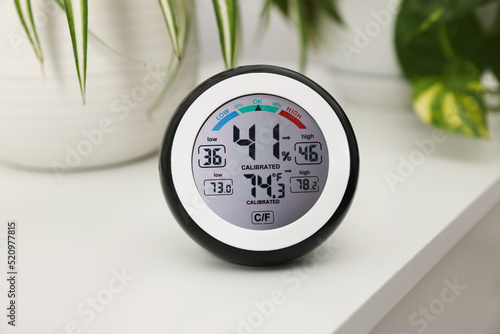 Photography Digital hygrometer with thermometer on white table, closeup