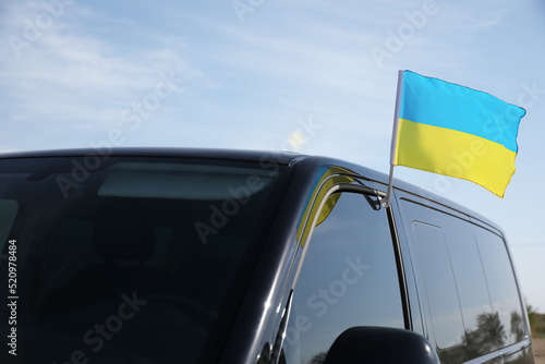 National flag of Ukraine on car window outdoors photo