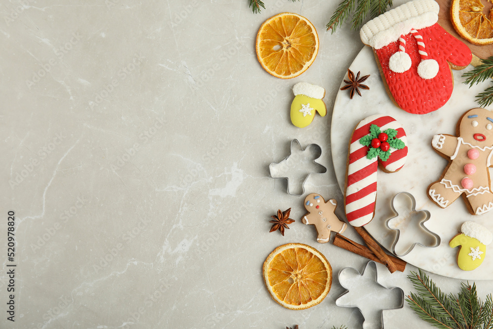 Flat lay composition with decorated Christmas biscuits and cookie cutters on light table. Space for text Flat lay composition with decorated Christmas biscuits and cookie cutters on light table. Space for text