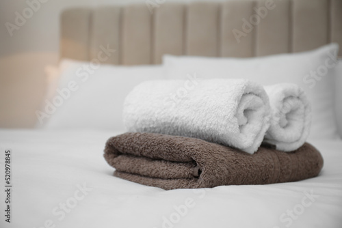Soft clean towels on white bed indoors © New Africa