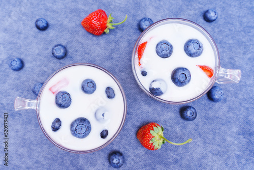 Top view of dairy berry desserts on blue backdrop