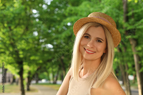Portrait of beautiful woman in straw hat outdoors on sunny day