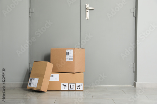 Cardboard boxes on floor near entrance. Parcel delivery service © New Africa