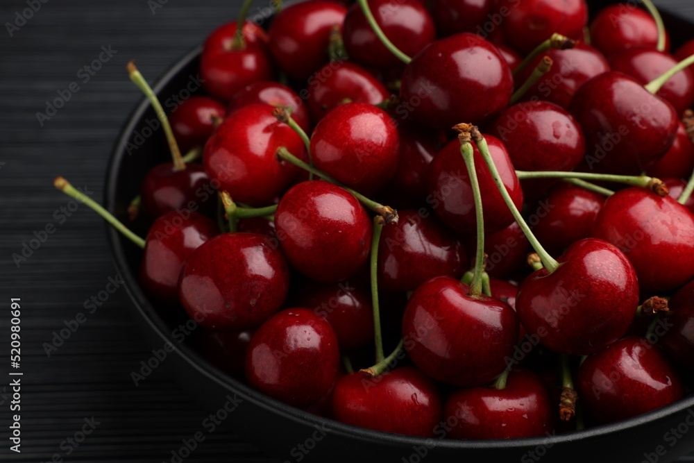 Bowl with ripe sweet cherries on dark wooden table, closeup Bowl with ripe sweet cherries on dark wooden table, closeup