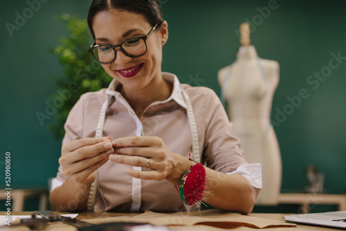 Female threading the needle at fashion studio