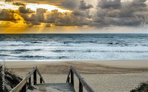 Passadiço para entrada na praia ao pôr do sol