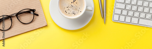 Office yellow backdrop with coffee  supplies and computer