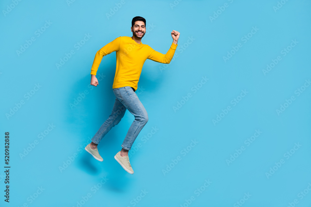 Full size profile photo of cheerful excited person jump rush fast empty space isolated on blue color background