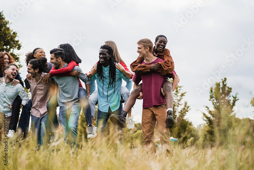 Young diverse friends, having fun outdoor laughing together - Focus on african man face