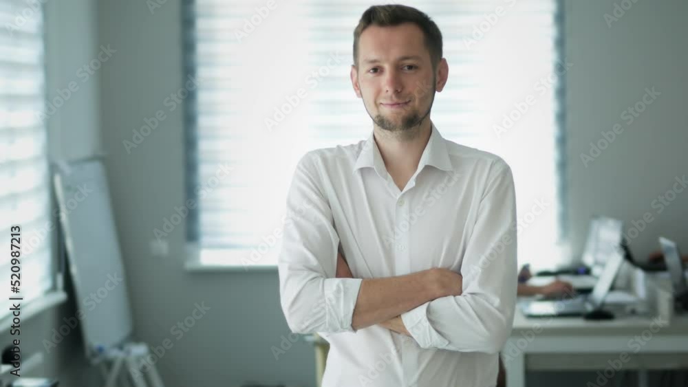 Portrait of happy office worker looking at camera in modern office, positive male employee with smiling face satisfied with good job career, close up portrait in slow motion Portrait of happy office worker looking at camera in modern office, positive male employee with smiling face satisfied with good job career, close up portrait in slow motion