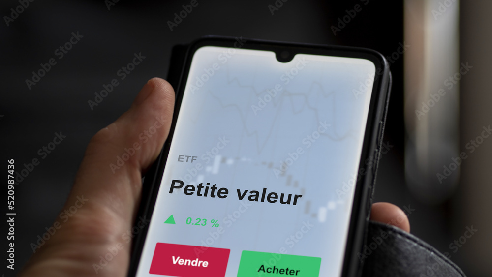 Un investisseur analyse un fonds etf petite valeur sur un graphique. Un téléphone affiche le cours de l'ETF. Texte en français francais petite valeur Un investisseur analyse un fonds etf petite valeur sur un graphique. Un téléphone affiche le cours de l'ETF. Texte en français francais petite valeur