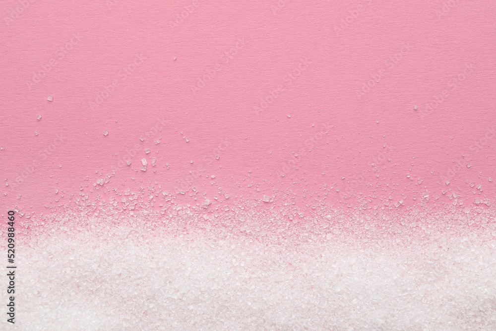 Granulated sugar on pink background, top view. Space for text Granulated sugar on pink background, top view. Space for text