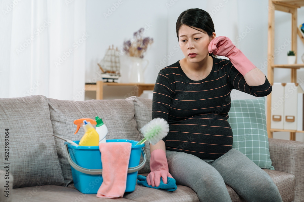 asian expectant pregnant mom is mopping sweat with hand