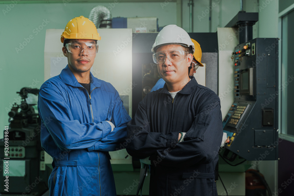Two Heavy Industry Engineers Stand in Steel Metal Manufacturing Factory. Asian male Industrial Specialist Talk to Technician. Two Heavy Industry Engineers Stand in Steel Metal Manufacturing Factory. Asian male Industrial Specialist Talk to Technician.