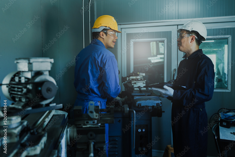 Industry Engineers and Worker Stand in Steel Metal Manufacturing Factory, use report paper and Have a Discussion. Asian male Industrial Specialist Talk to Technician. Industry Engineers and Worker Stand in Steel Metal Manufacturing Factory, use report paper and Have a Discussion. Asian male Industrial Specialist Talk to Technician.