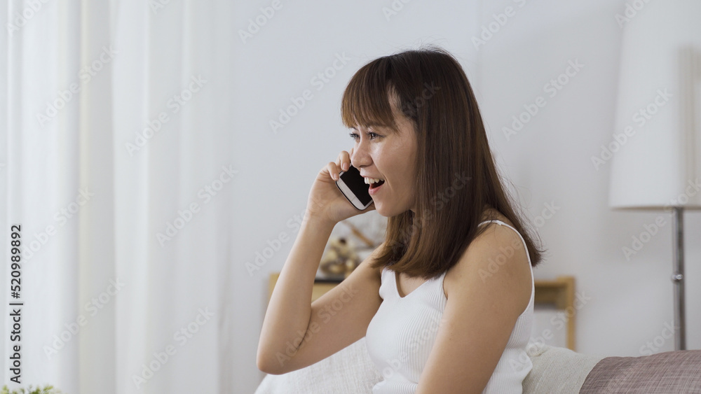 side view attractive japanese lady having pleasant phone talk with friend during leisure time on weekends at home. side view attractive japanese lady having pleasant phone talk with friend during leisure time on weekends at home.