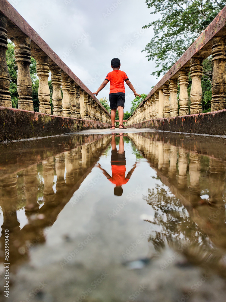 Water reflection of a boy inside of a corridor