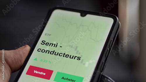 Un investisseur analyse un fonds etf semi - conducteurs sur un graphique. Un téléphone affiche le cours de l'ETF. Texte en français francais Semi - conducteurs