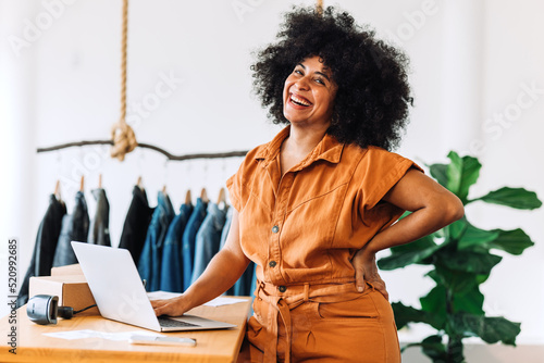 Black small business owner smiling at the camera in her shop photo