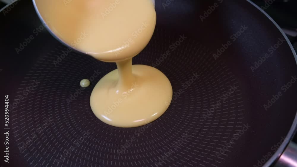 slow motion Pouring pancake mixture frying pan closeup American breakfast slow motion Pouring pancake mixture frying pan closeup American breakfast