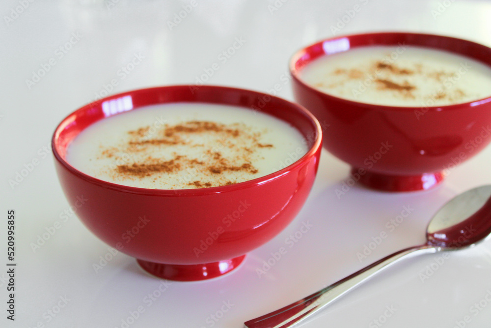 Milky dessert in the bowls, light pudding with cinnnamon powder Milky dessert in the bowls, light pudding with cinnnamon powder