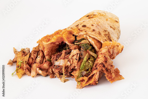 Isolated on a white background, spoiled and greasy and unhealthy doner or shawarma. Harmful and dangerous fast and street food photo