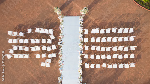 Many white chairs at the Wedding ceremony. Aerial drone view. Elegant decoration of a wedding ceremony outdoors. Outdoor wedding ceremony.