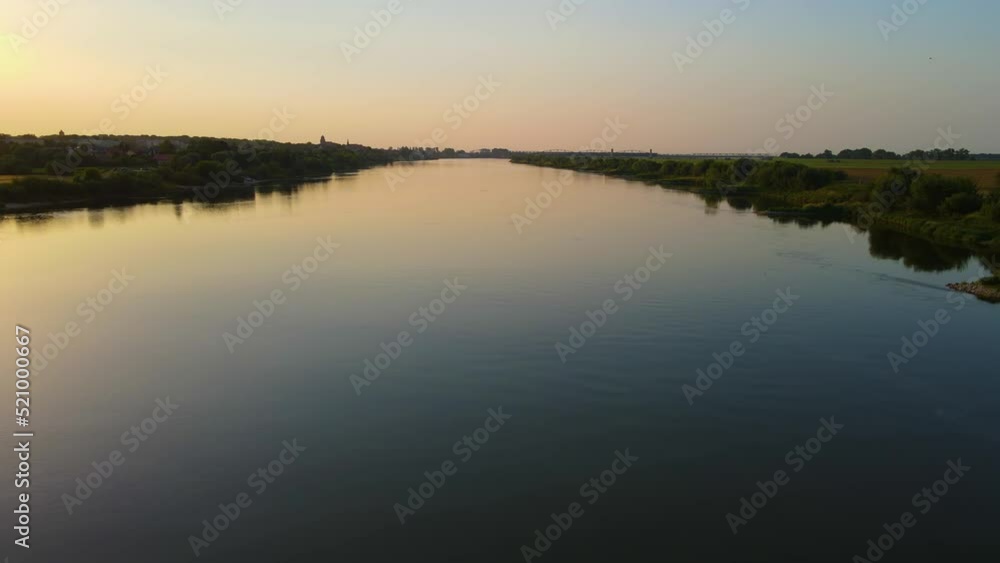 Aerial shot of sunset on river, drone flying left over water in evening. Global warming concept Aerial shot of sunset on river, drone flying left over water in evening. Global warming concept
