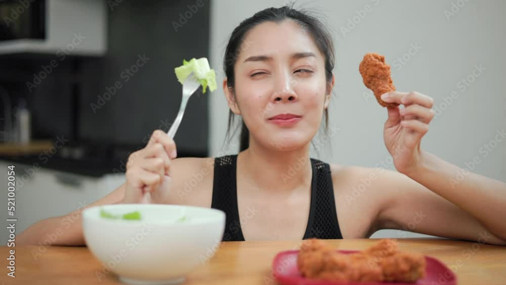 Beautiful female stop eat fried chicken junk food and make healthy food choices greens vegetable salad in weight loss diet and wellness on table. Woman chooses clean food for breakfast. Diet concept. Beautiful female stop eat fried chicken junk food and make healthy food choices greens vegetable salad in weight loss diet and wellness on table. Woman chooses clean food for breakfast. Diet concept.
