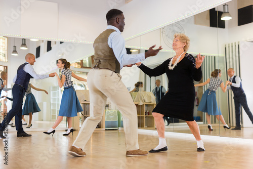 Woman pensioner with african man practising charleston