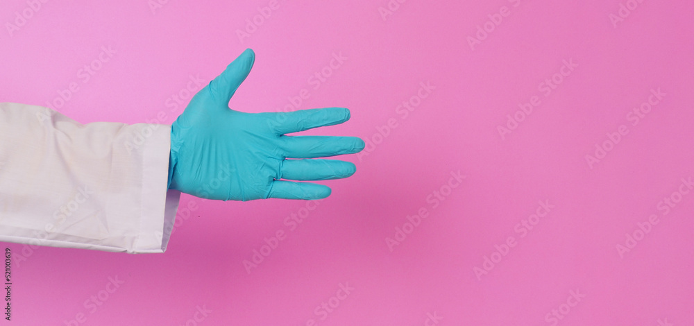 Empty hand Doctor hands wear blue latex glove on pink background.He wear long sleeve gown. Empty hand Doctor hands wear blue latex glove on pink background.He wear long sleeve gown.