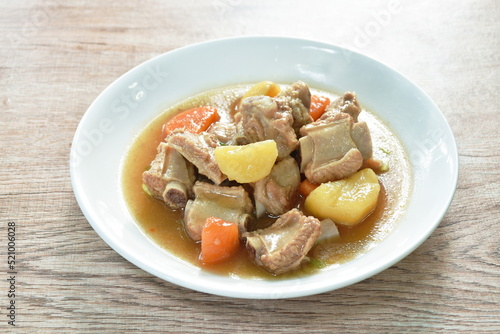 boiled pork bone with potato and carrot stew on plate